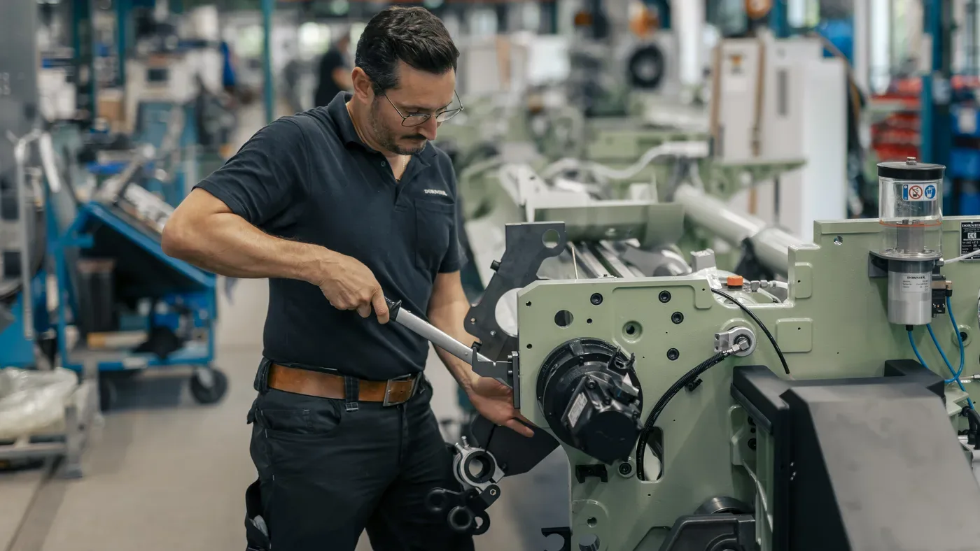 DORNIER service technician working on a weaving machine